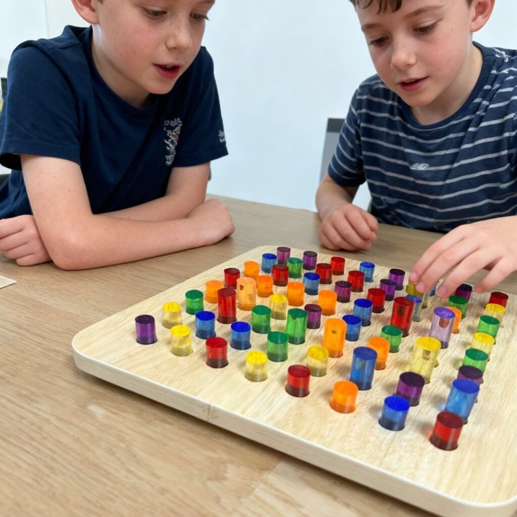 Two kids building a design on the light up peg board sensory toy