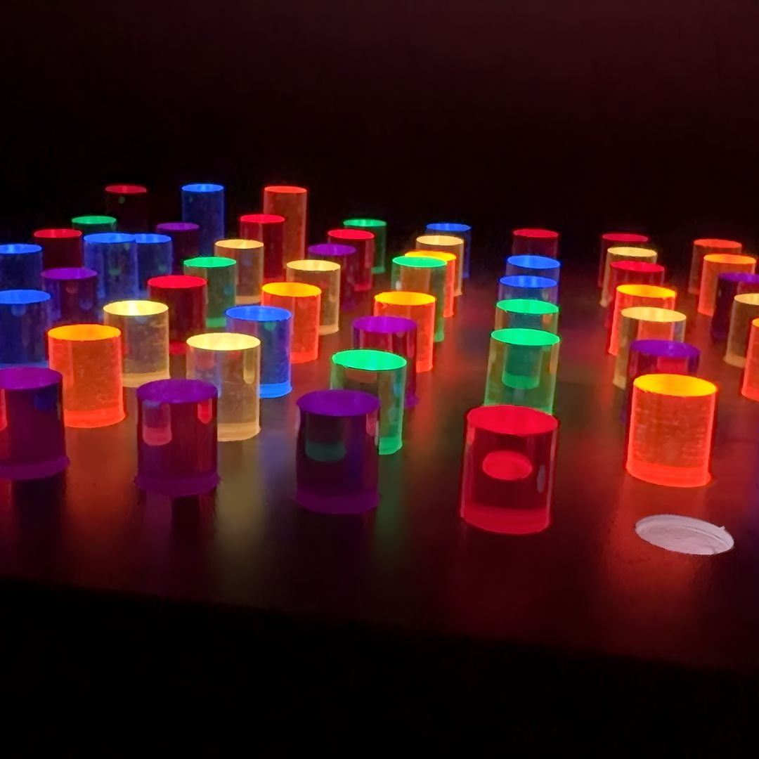 Close-up of glowing LED acrylic pegs on the light up peg board in the dark