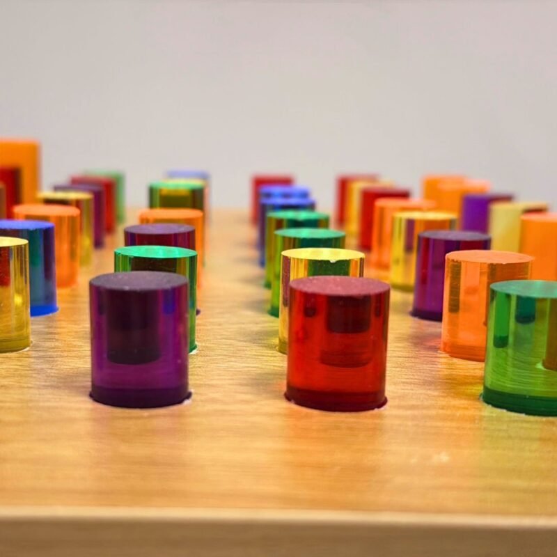 Close-up of colorful acrylic pegs on the wooden light up peg board